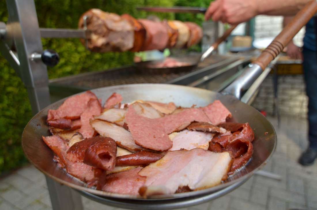 De Vleesspies draait boven de barbecue en het vlees wordt in reepjes afgesneden en valt in het pannetje. Eventueel kunt u het vlees in het pannetje nog iets meer knapperig bakken.